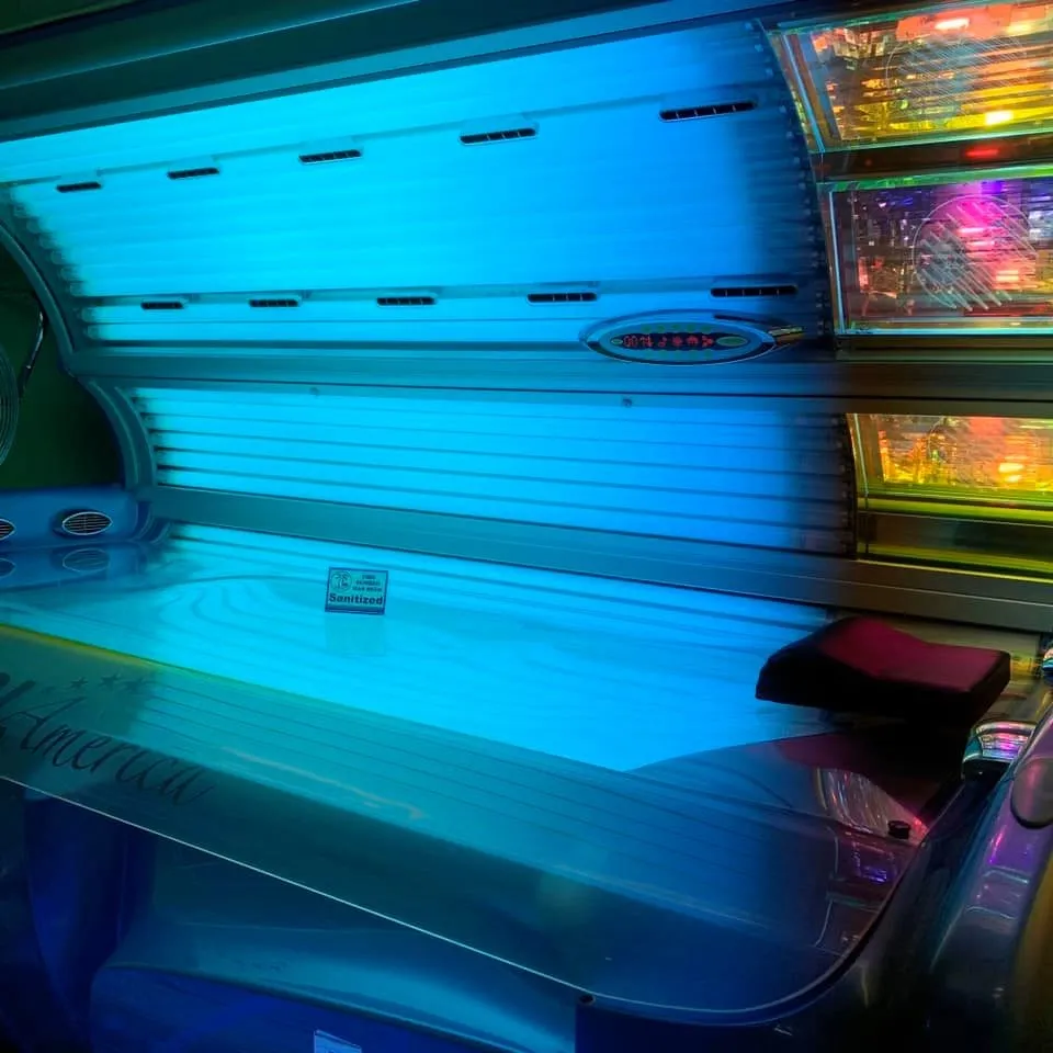 An open tanning bed with its lamps lit aqua