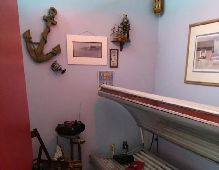 The red light therapy bed, in a room hung with an anchor and seaside pictures